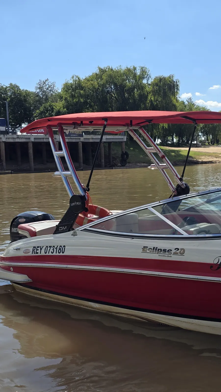 Torre DM Matrix en aluminio pulido con bimini rojo, sobre una Eclipse 20 amarrada